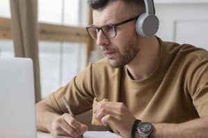 Como se inscrever em um Concurso Público? Homem usando seu notebook para se inscrever em concurso