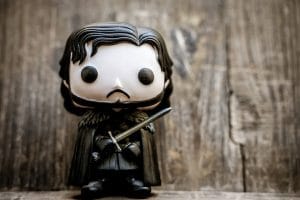 Game of Thrones - Boneco de Jon Snow, da série Funko! Pop, com uma superfície de madeira ao fundo.