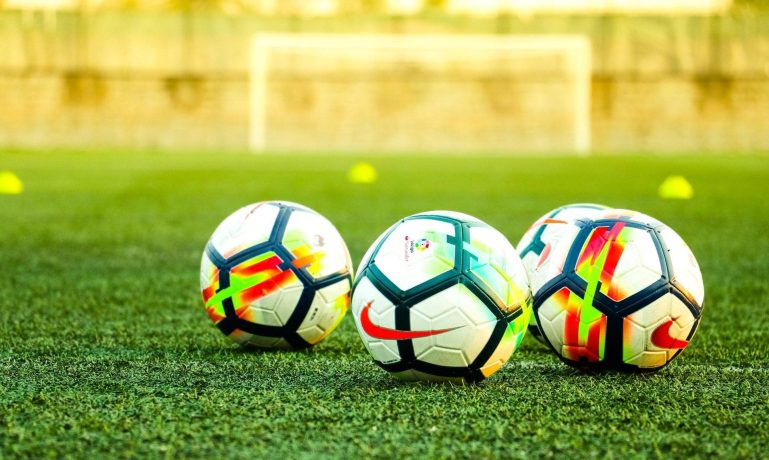 Bolas de futebol no gramado - campo de futebol