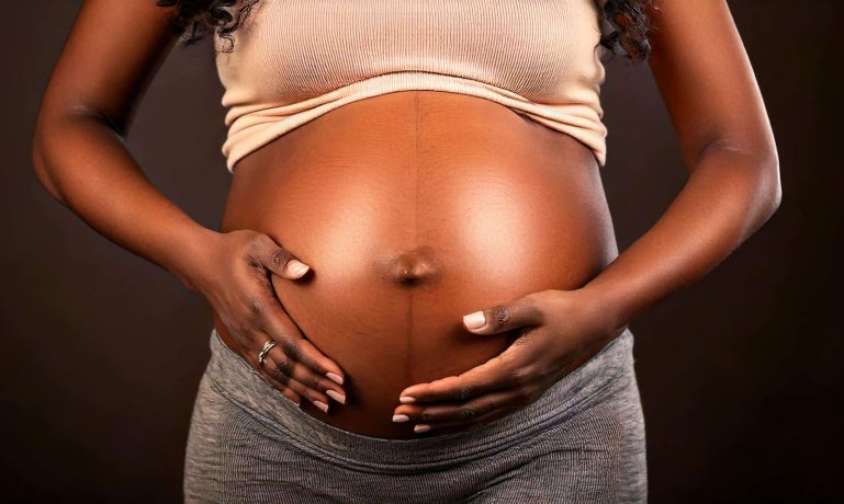 Imagem de uma mulher grávida segurando a barriga representando que quem recebe Bolsa família pode receber Auxílio-maternidade?