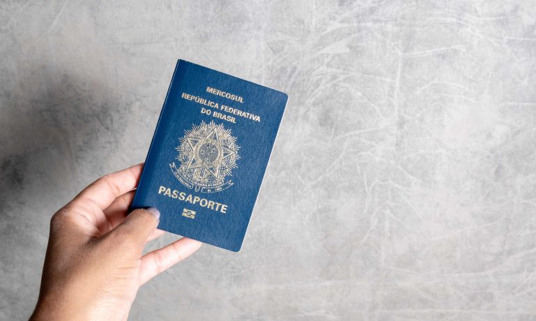 Mulher segundo um passaporte em um fundo cinze, e ela conseguiu fazer a renovação do passaporte