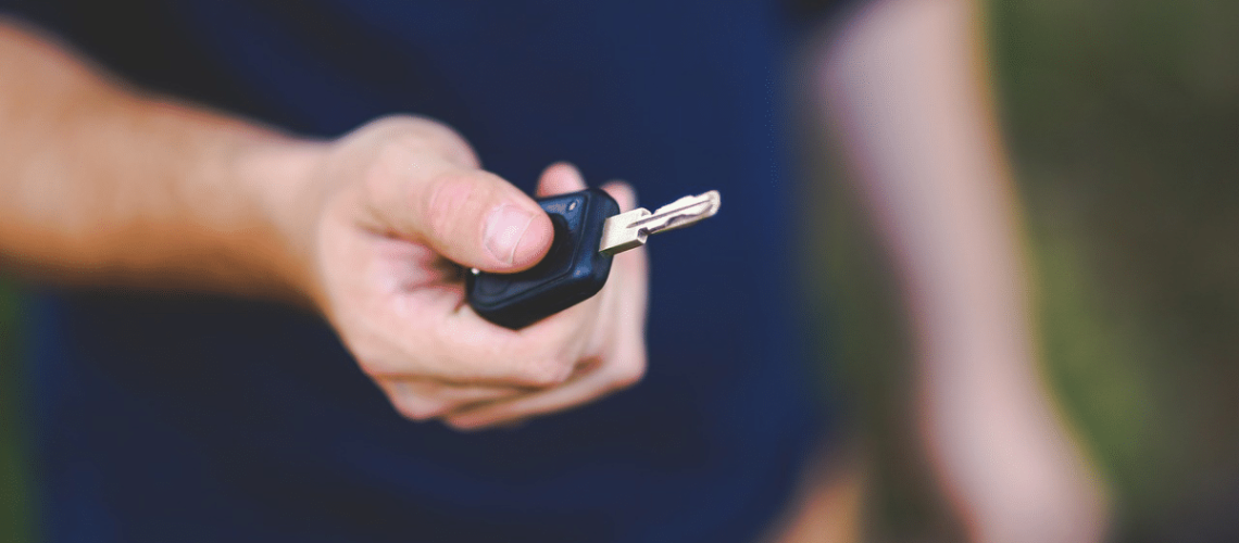 Homem segurando a chave do seu carro que teve o Licenciamento atrasado
