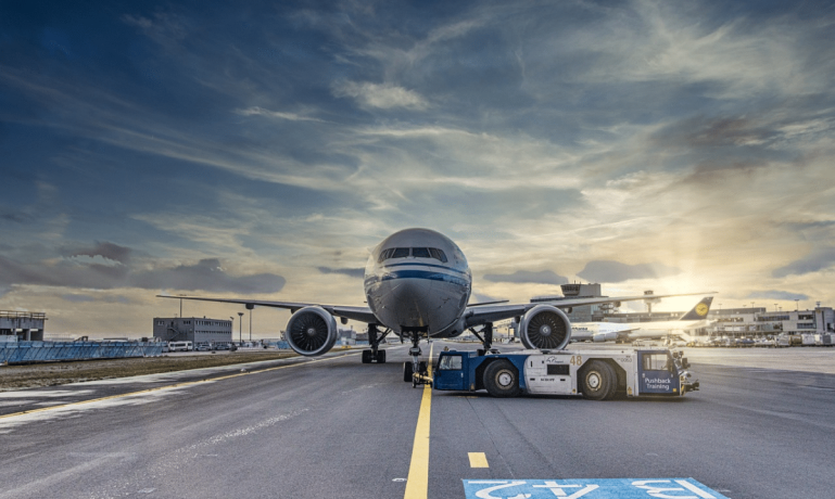 Imagem de um avião em um aeroporto representando a Passagem de avião barata para idosos