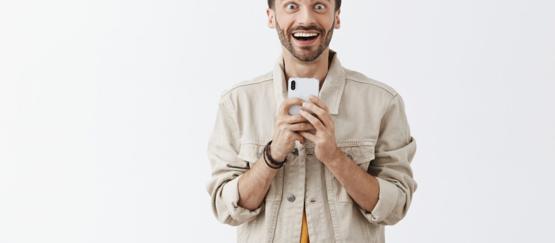 homem feliz no celular