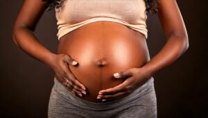 Imagem de uma mulher grávida segurando a barriga representando que quem recebe Bolsa família pode receber Auxílio-maternidade?