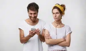homem conversando em aplicativos de namoro e mulher desconfiada
