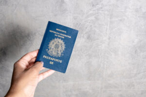 Mulher segundo um passaporte em um fundo cinze, e ela conseguiu fazer a renovação do passaporte