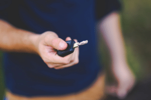 Homem segurando a chave do seu carro que teve o Licenciamento atrasado