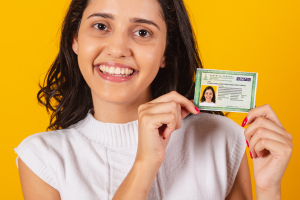 Mulher segurando a sua carteira de habilitação e ela descobriu como renovar CNH